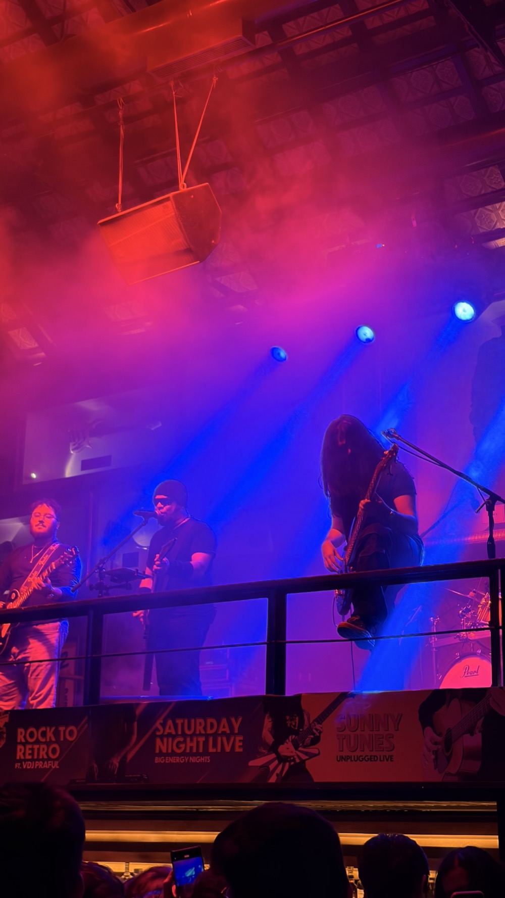 Band performing live under blue and red stage lights