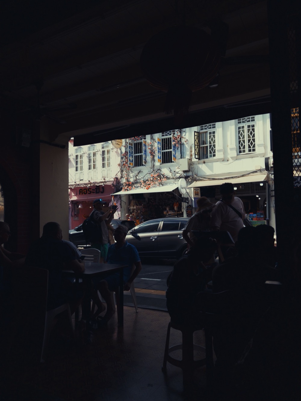 Street view from inside a shaded cafe doorway