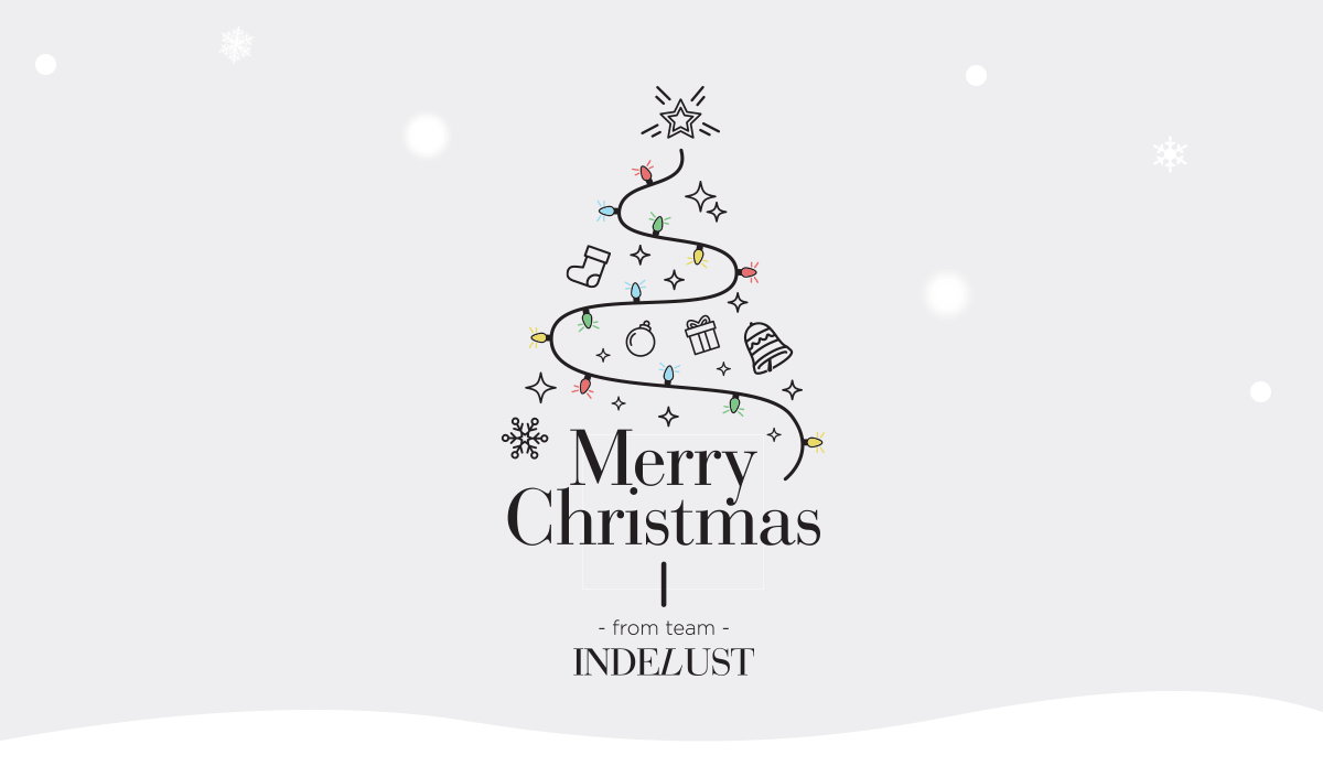 An animated Indelust holiday greeting: a line-drawn Christmas tree lights up with a string of twinkling bulbs over 'Merry Christmas from team Indelust'.